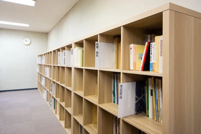 書棚に並ぶ資料と奥へ続く通路